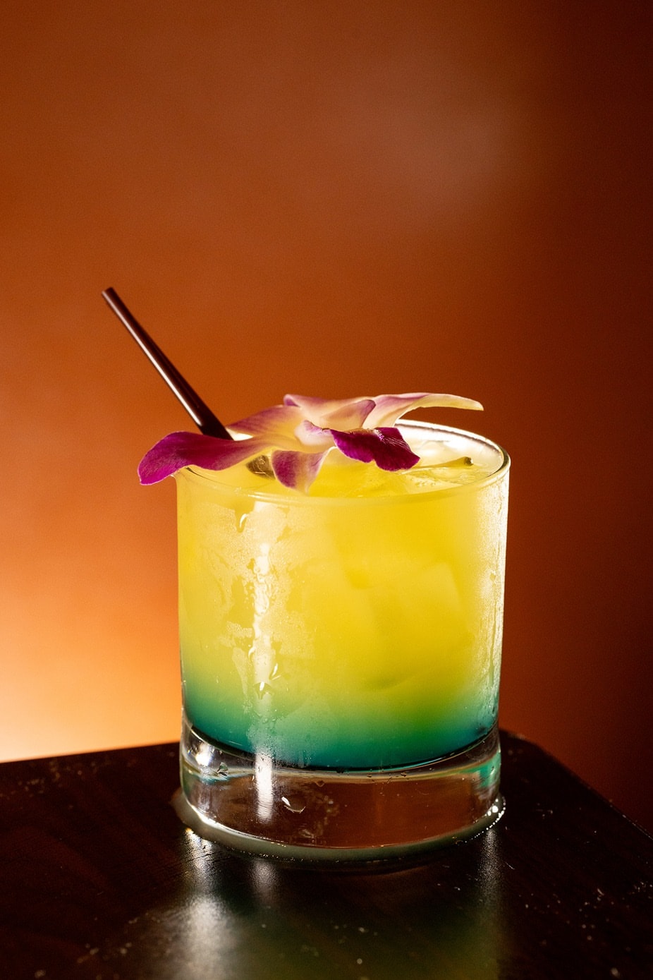 Tall tropical cocktail with orchid garnish