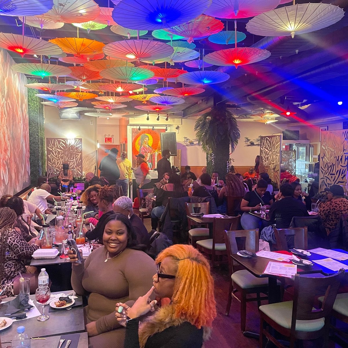Busy restaurant with colorful umbrella ceiling detail
